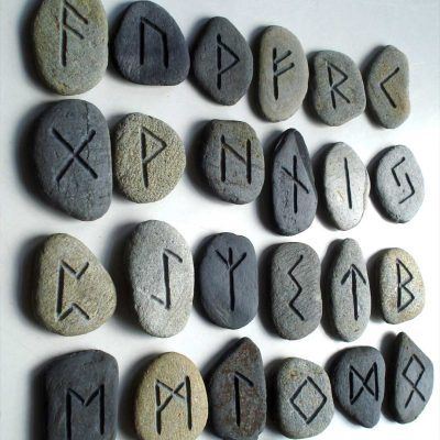 Foto de runas em pedras diversas inscritas com o alfabeto rúnico.